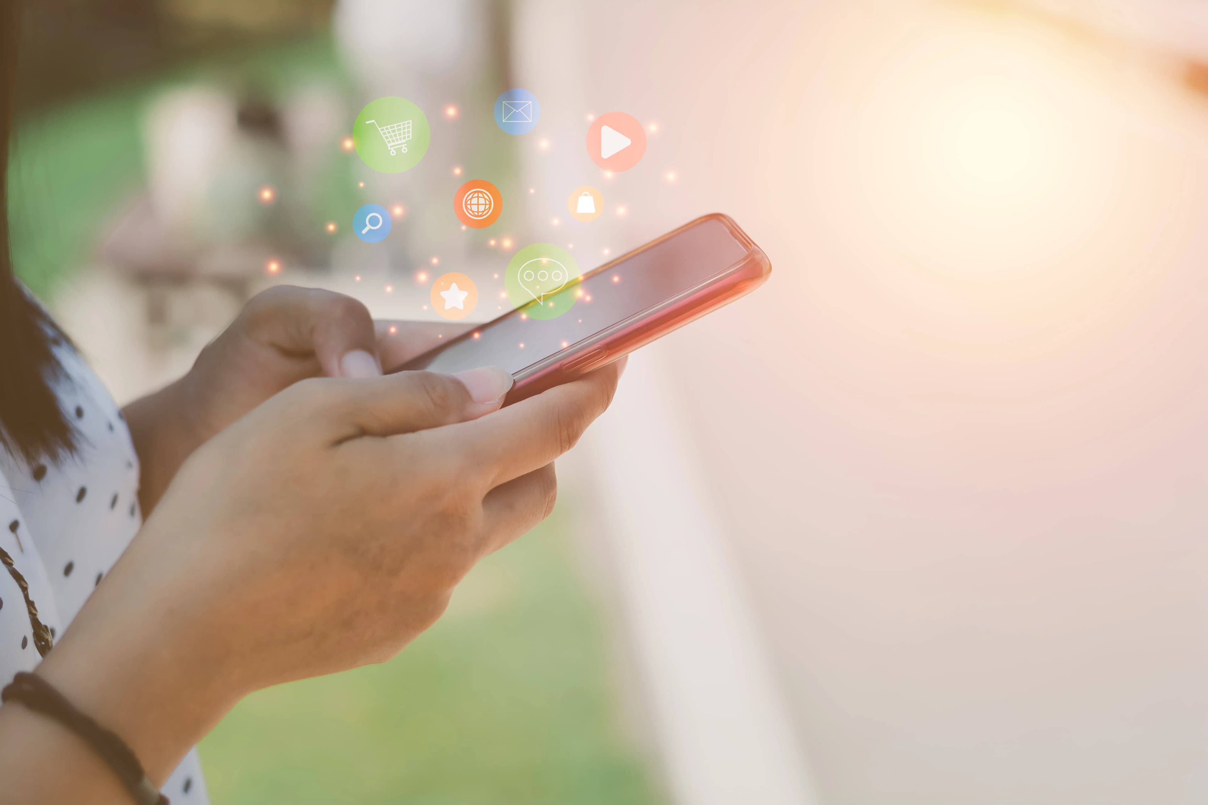 Like, heart and comment icons floating above a hand-held smartphone