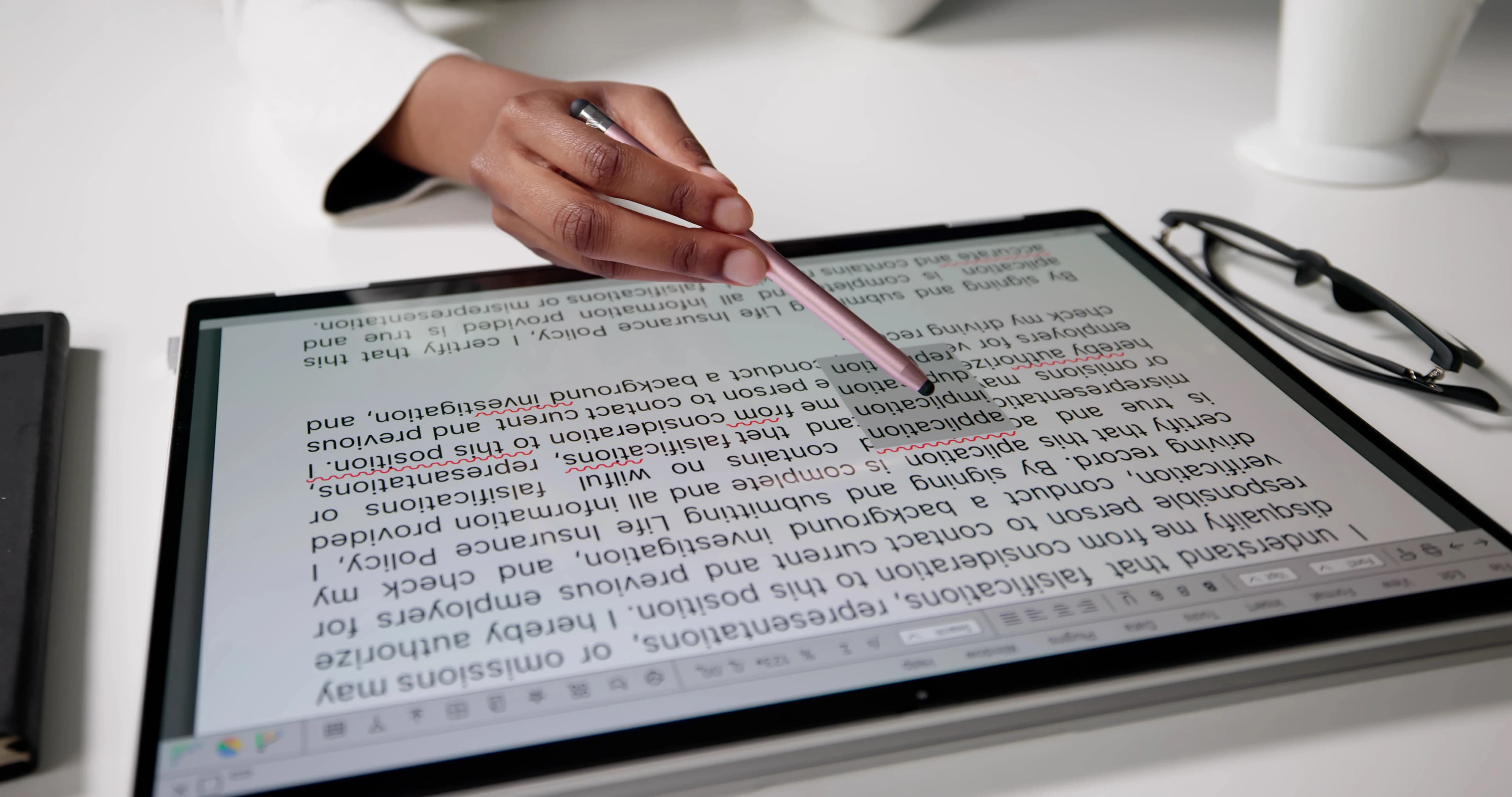 Editör tablette kalemle metni okuyup düzenliyor, yakın çekim
