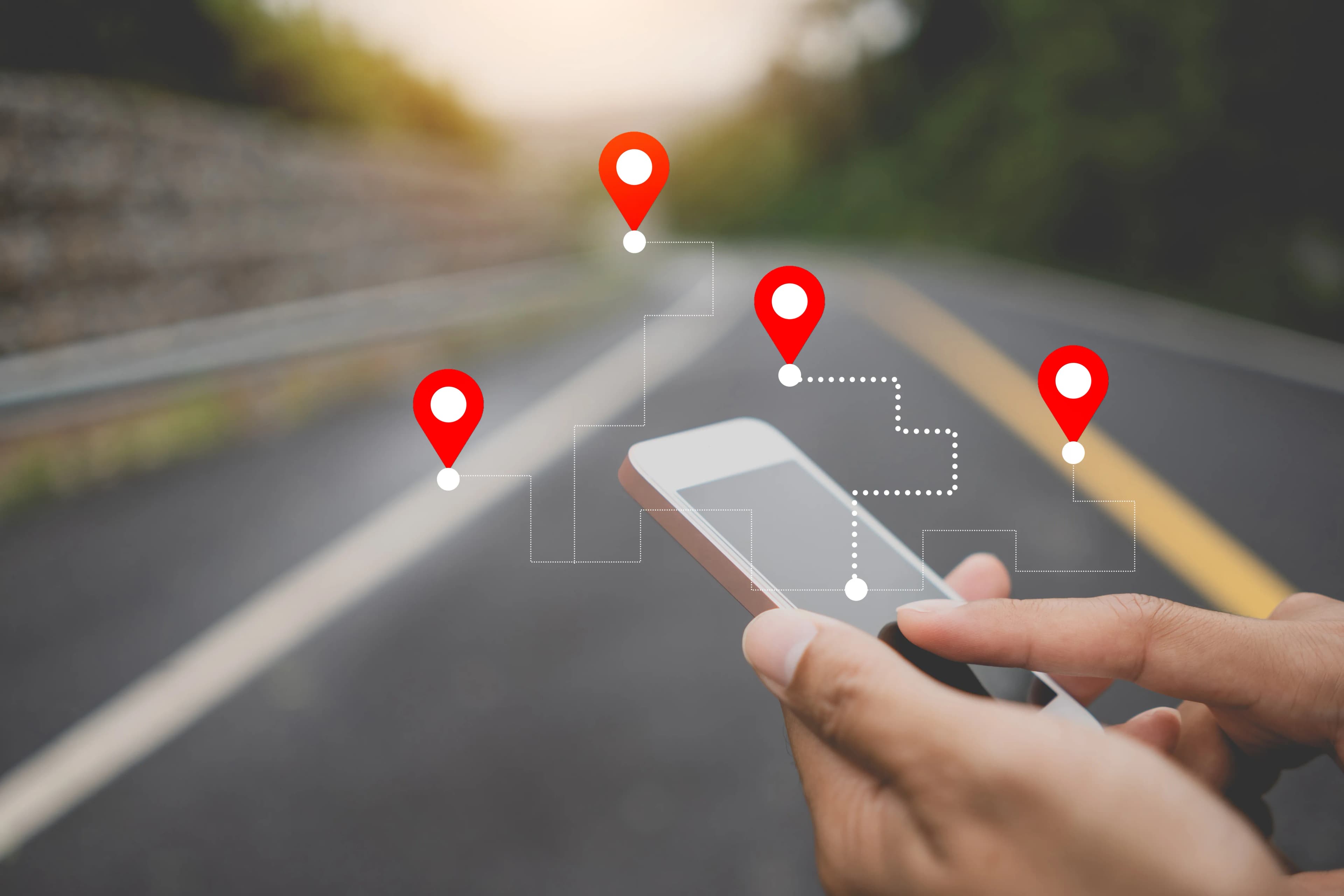 Map location pins above a hand-held phone on a street