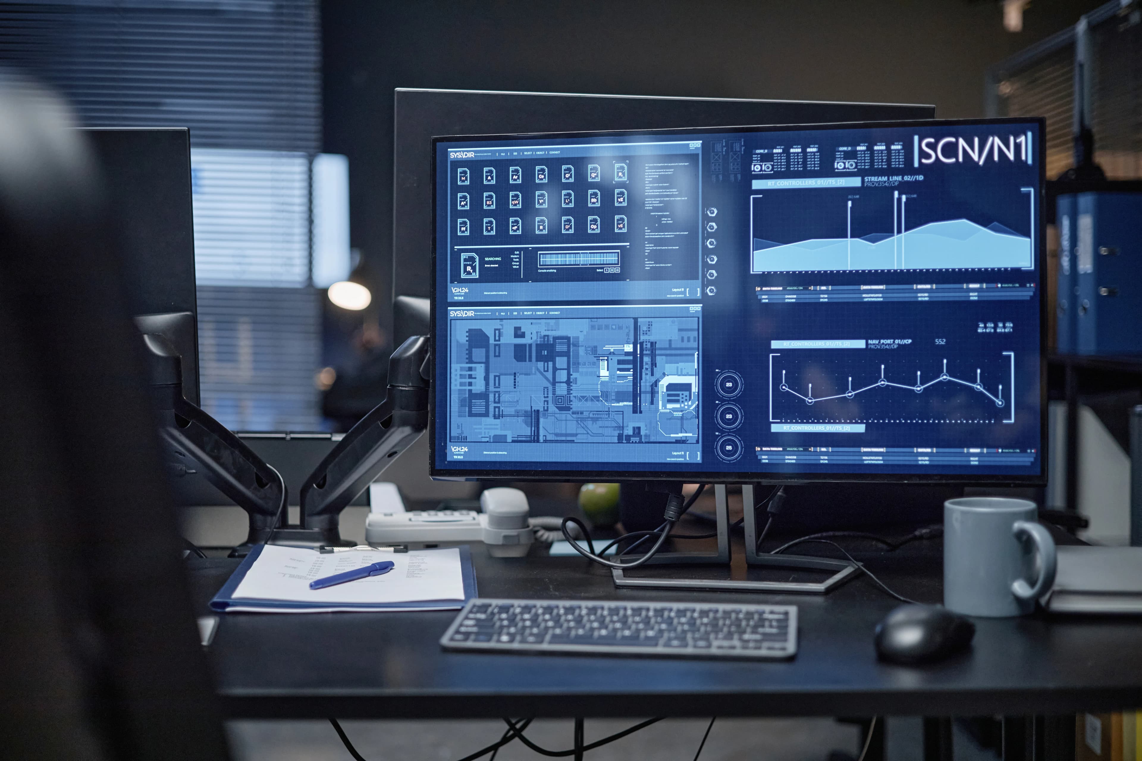 Ofis masasındaki büyük monitörde analitik grafikleri ve izleme panosu