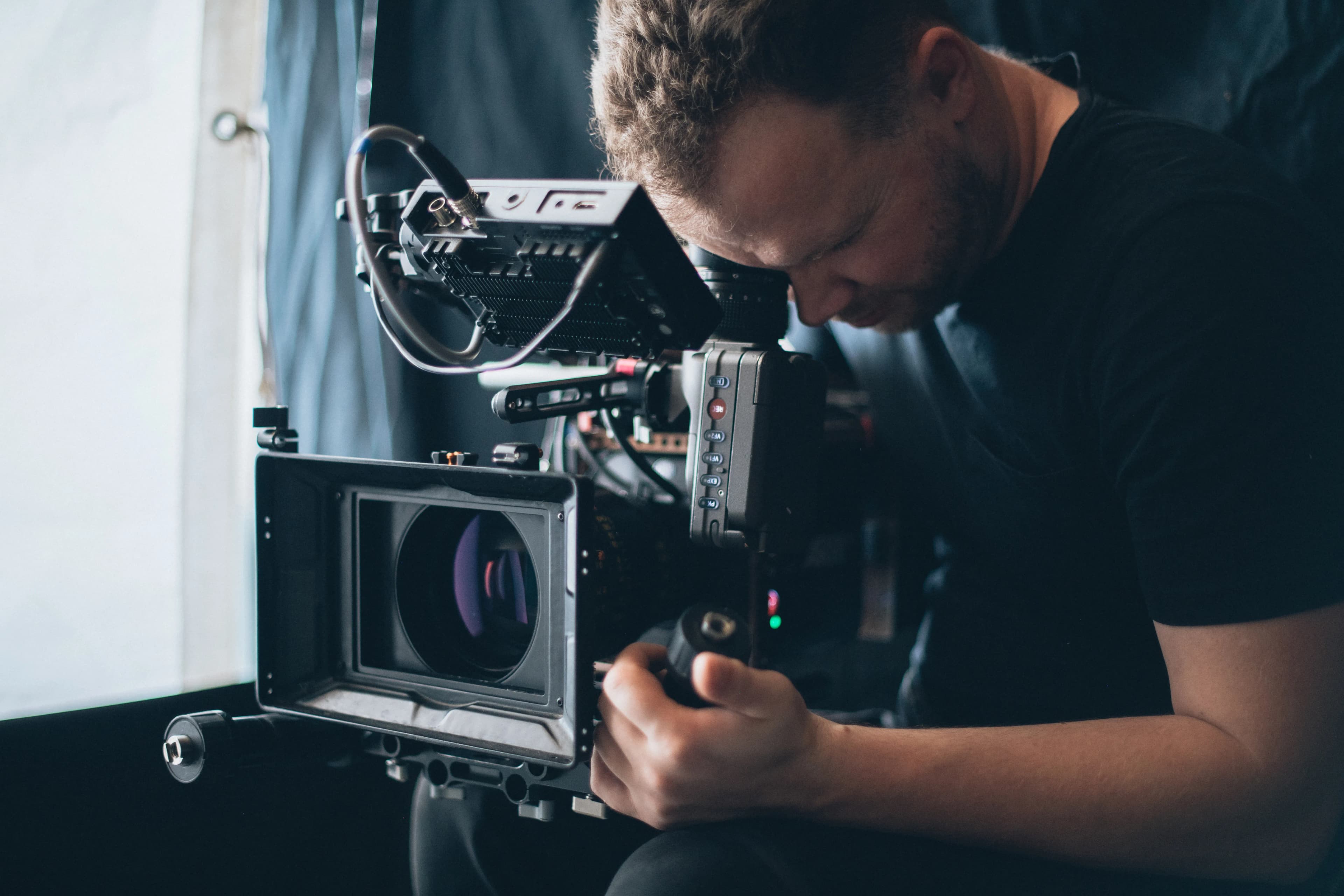 A director of photography filming with a cinema camera on set