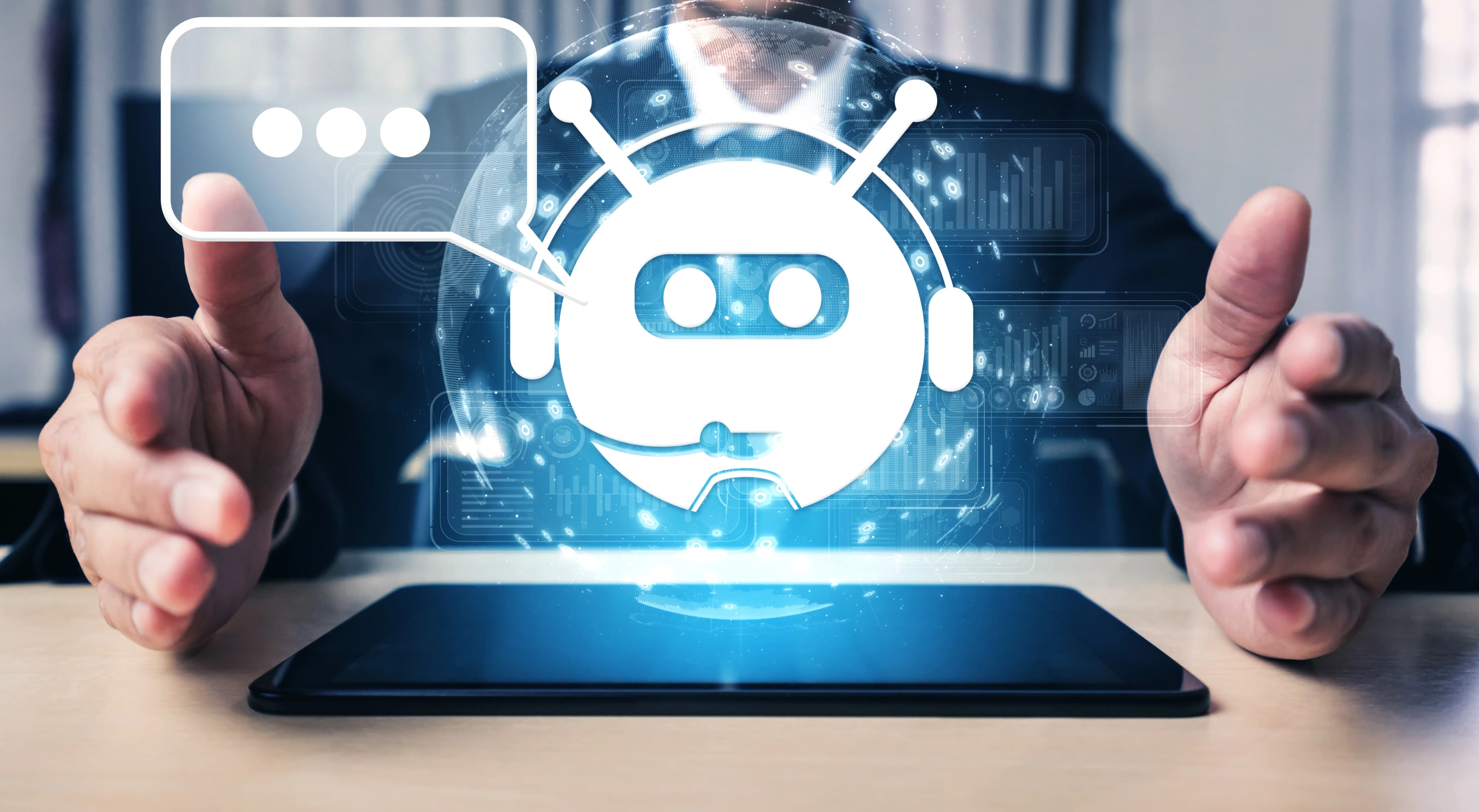A glowing chatbot icon above a hand-held tablet