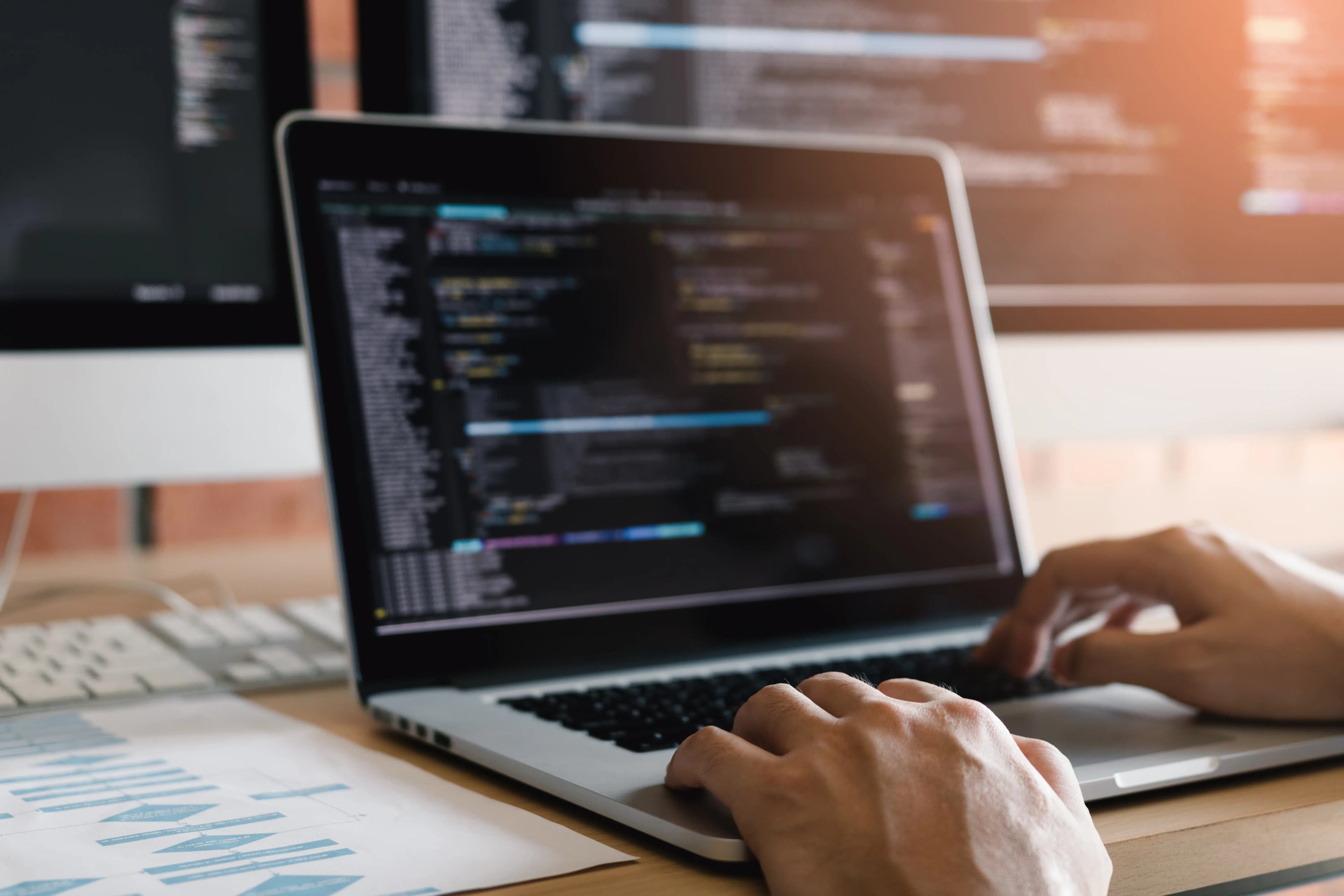 Web geliştiricisi laptop ekranındaki kodu yazıyor, yakın çekim